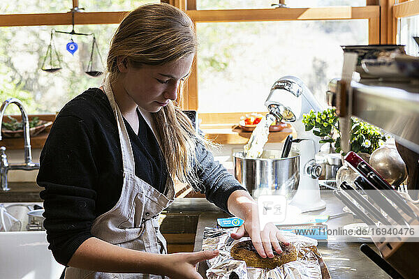 Teenage girl in kitchen baking a cake.