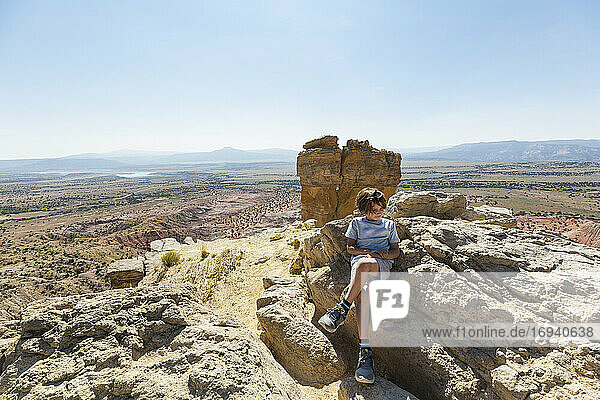 Boy hiking to the top of Chimney Rock landmark in a protected canyon landscape