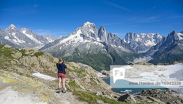 Young woman photographs mountain panorama  Lac Blanc  mountain peaks  Grandes Jorasses and Mont Blanc massif  Chamonix-Mont-Blanc  Haute-Savoie  France  Europe