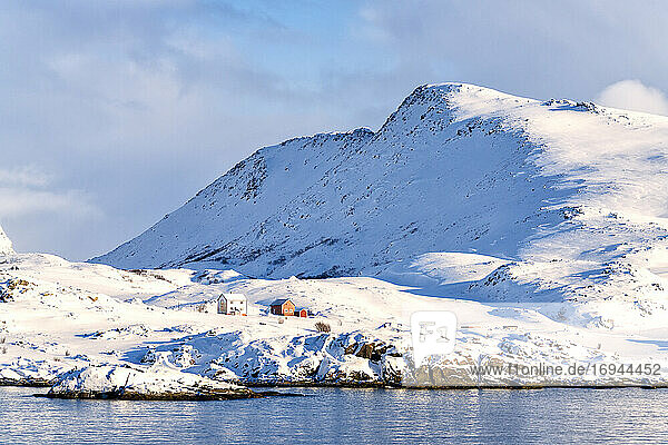 Wintersonne über isolierten Fischerhütten im Schnee  Hasvik  Insel Soroya  Troms og Finnmark  Arktis  Nordnorwegen  Skandinavien  Europa