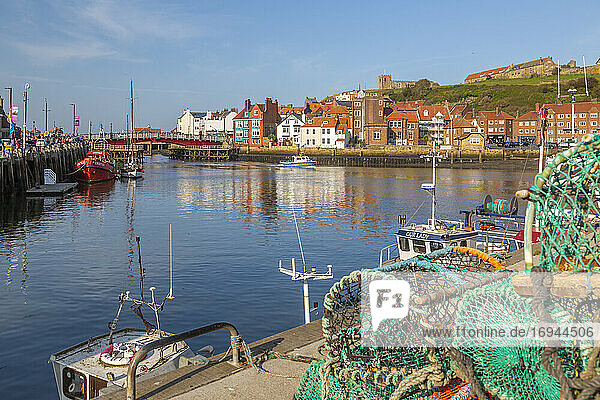 View of St. Mary's Church and fishing baskets  houses and boat on the River Esk  Whitby  Yorkshire  England  United Kingdom  Europe