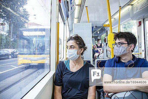 Eine Mutter und ihr Sohn tragen Gesundheitsschutzmasken in einer öffentlichen Straßenbahn (Oberleitungswagen)  Lissabon  Portugal  Europa