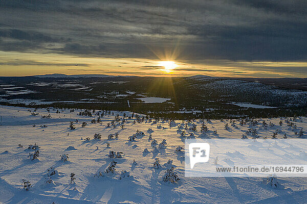Arktischer Sonnenuntergang über dem verschneiten Wald und Skigebiet von Levi  Sirkka  Gemeinde Kittila  Lappland  Finnland  Europa