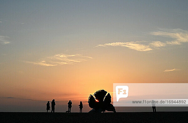 Menschen bei Sonnenaufgang neben The Scallop  Skulptur von Maggi Hambling 2003  zum Gedenken an Benjamin Britten  Aldeburgh  Suffolk  England  Vereinigtes Königreich  Europa