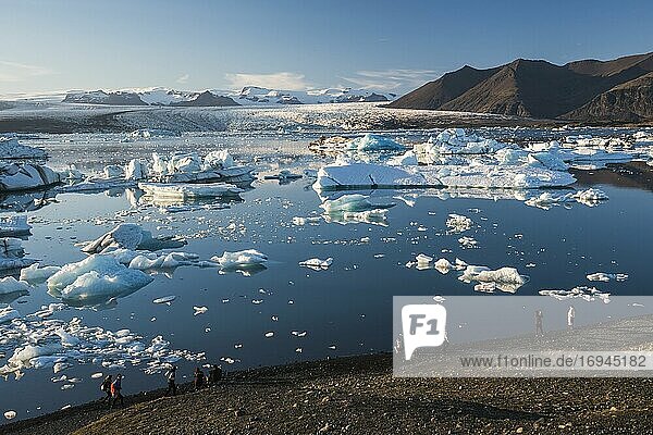 Eisberge in der Gletscherlagune Jokulsarlon  die aufgrund der globalen Erwärmung und des Klimawandels schmelzen  dahinter die Eiskappe des Vatnajokull  Südostisland