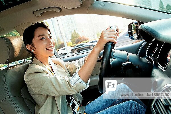 Glückliche junge Frau am Steuer eines Autos