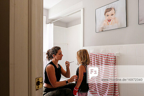Mutter und Tochter im Badezimmer  die die Temperatur am Thermometer ablesen