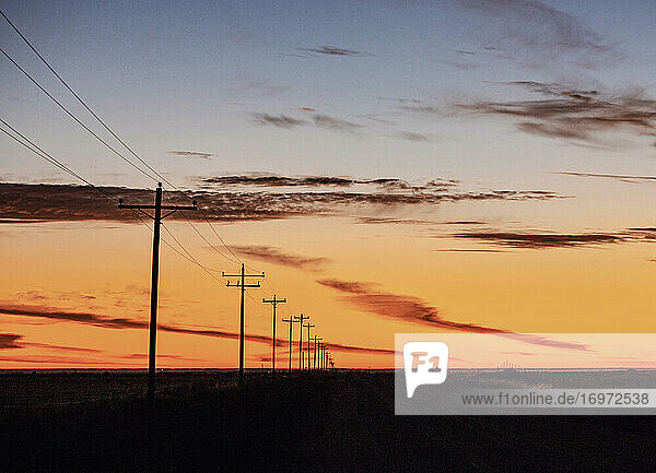 Stromleitung  die bei Sonnenaufgang im Mittleren Westen der USA in die Ferne rückt