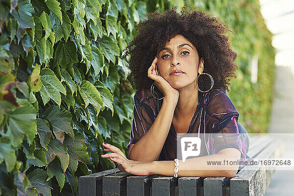 Eine schöne Frau  die in einem Park liegt und schönes Afro-Haar hat.