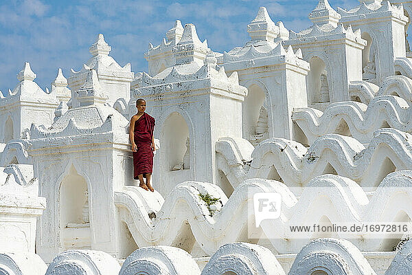 Novizenmönch vor der weißen Hsinbyume-Pagode (auch bekannt als Myatheindan-Pagode)  Mingun  Mandalay  Gemeinde Sagaing  Bezirk Sagaing  Region Sagaing  Myanmar