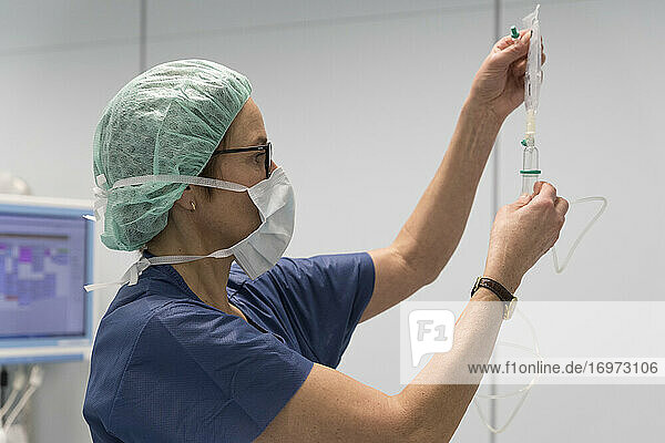 ein Anästhesist bereitet im Operationssaal eine Infusion vor