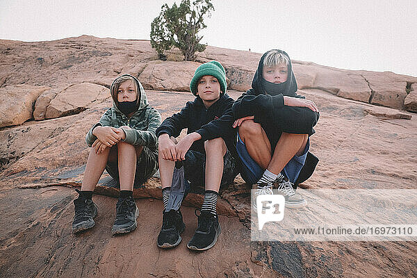 Drei junge Burschen auf einer Wanderung in der Wüste während des Covid