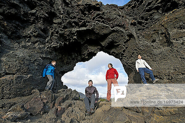 Familie posiert am Natursteinbogen am Myvatn-See in Island