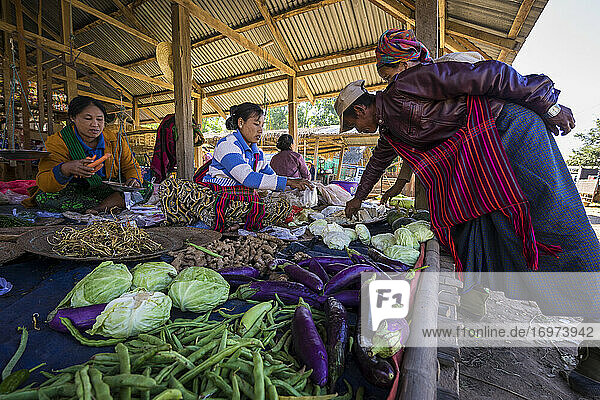 Frauen verkaufen frisches Gemüse auf dem Straßenmarkt in einem Dorf am See