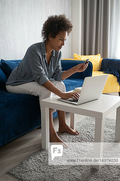 Schwarze Frau beim Stöbern auf der Website eines Online-Shops