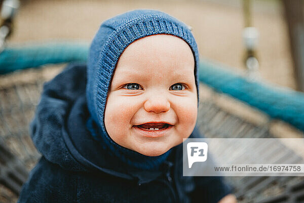 Entzückendes Baby mit zwei Vorderzähnen lächelt im kalten Winter