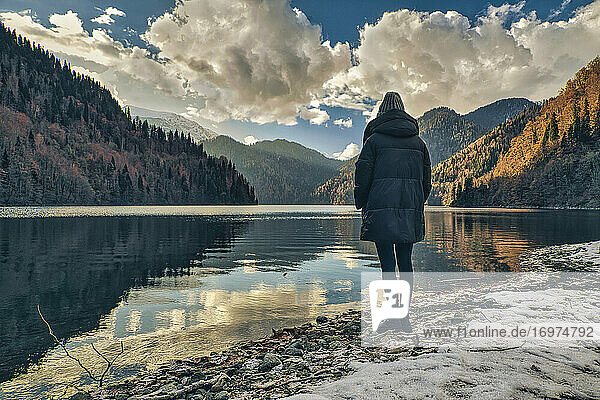 Woman standing on lakeside in morning time