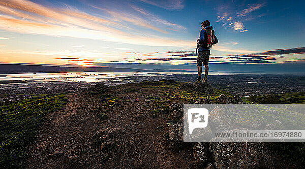 Wanderer auf einem Felsen mit Blick auf die Bucht von San Francisco bei Sonnenuntergang