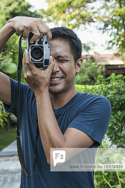 Mann fotografiert mit analoger Entfernungsmesserkamera