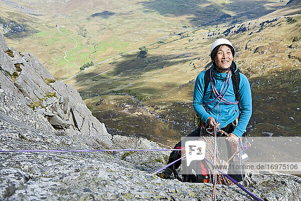 female rock climber at belay anchor point on Tryfan in North Wales