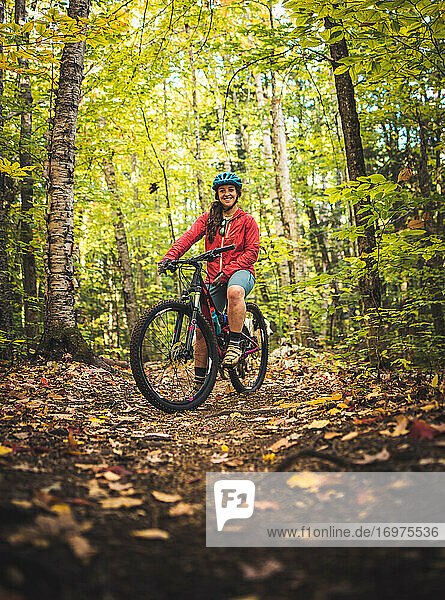 Portrait of female mountain biker standing on trail