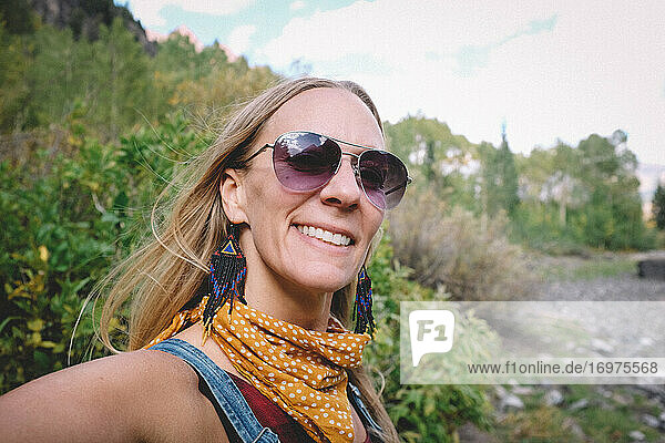 Happy Blonde Woman in Sunglasses Takes Selfie on a Hike