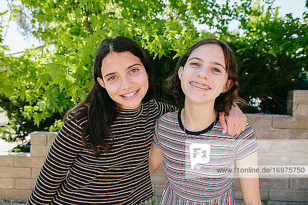 Teen und Tween Sisters tragen Streifen und lächeln für die Kamera