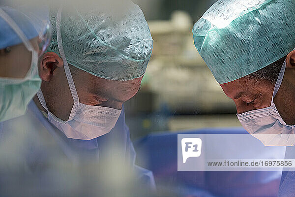 eine Gruppe von Chirurgen kümmert sich im Operationssaal um einen Patienten