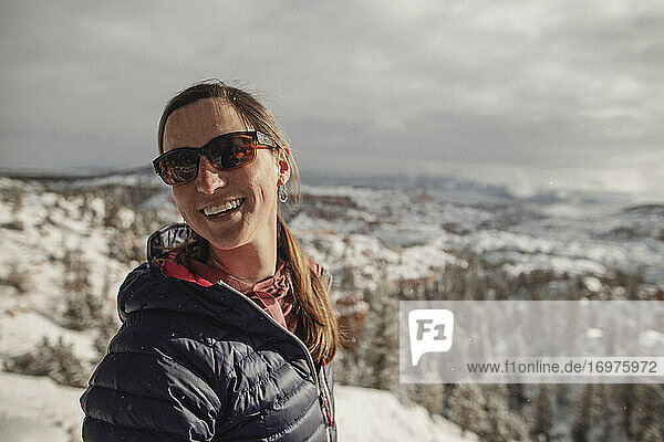 woman hiker smiles at viewpoint of Bryce Canyon  Utah in fresh snow