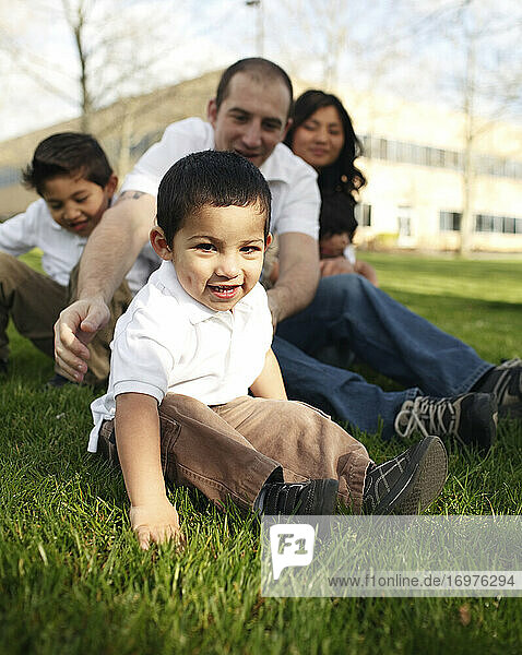Familiy sitting in the grass in park