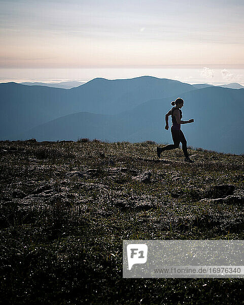 Silhouette of woman running through mountains in New Hampshire