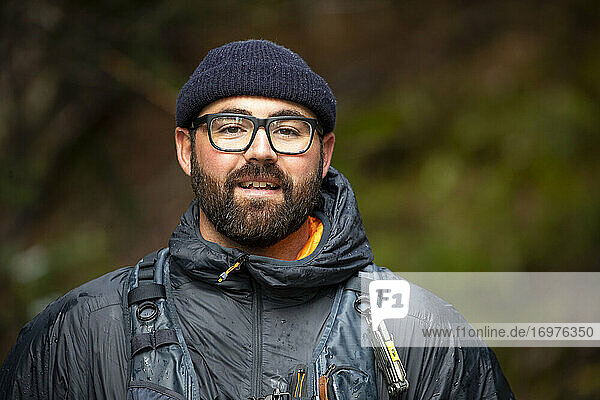 Portrait of an outdoor adventuring bearded man with glasses in nature