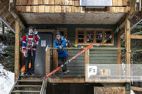 Männliche Eishockeyspieler stehen auf der Veranda einer Hütte