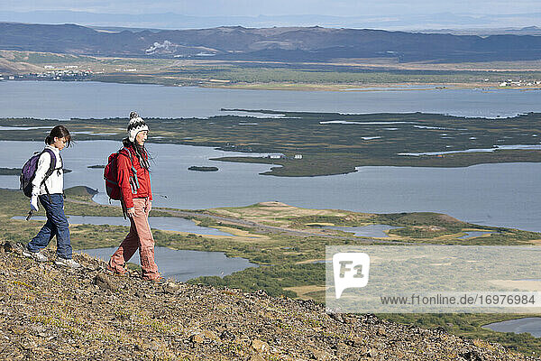 Mother and daughter ascending from mountain at Lake Myvatn
