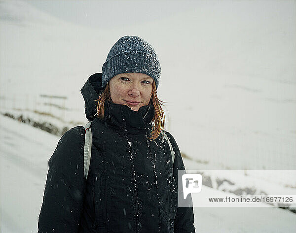 Portrait of smiling woman  in the snow  looking at camera  in the Faroe Islands
