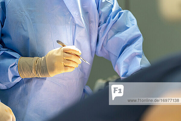 ein Chirurg hält ein Skalpell in seiner Hand