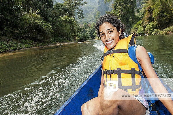 Junge Frau genießt eine Fahrt auf einem Longtailboot in Laos
