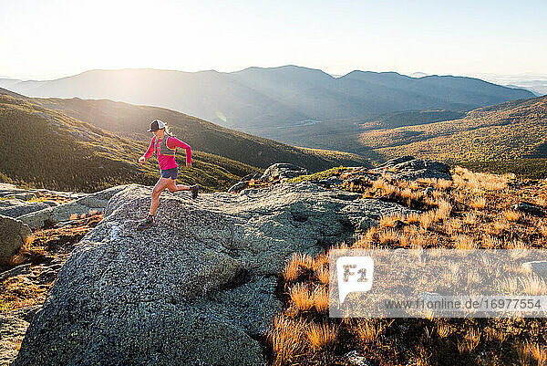 Woman running in the White Mountains at sunrise in summer