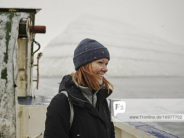 Frau auf Fähre mit Blick auf die Berge der Färöer Inseln
