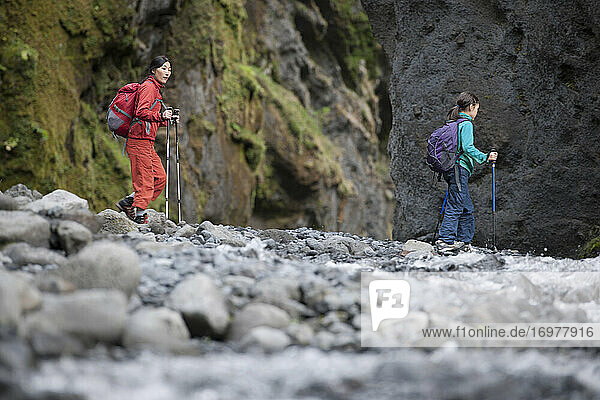 Mutter und Tochter wandern durch eine Schlucht in Island