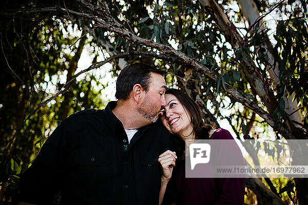 Ehemann und Ehefrau posieren unter einem Baum im Park in Chula Vista