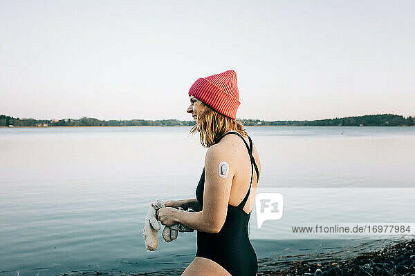 Frau im ruhigen Wasser  bereit zum Kaltwasserschwimmen in Schweden