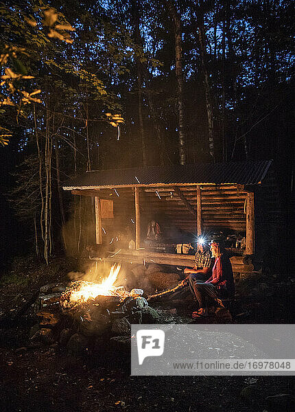 Ein Paar sitzt an einem Lagerfeuer vor einer Schutzhütte auf dem Appalachian Trail