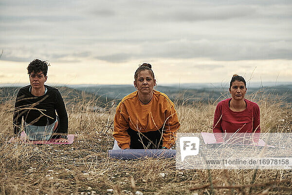 3 junge Frauen üben Pilates im Freien