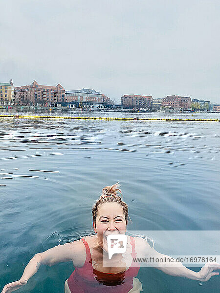 Lächelnde Frau voller Freude Kaltwasserschwimmen in Dänemark
