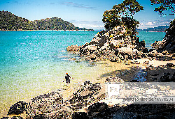 Frau erkundet Strand und Wasser im Abel Tasman National Park