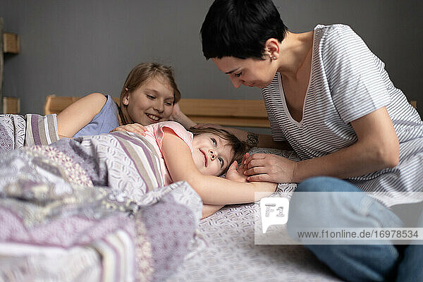 Mother waking up daughters in morning