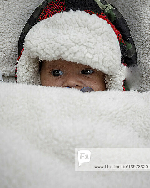 Cute neugeborenes Baby in gemütlichen Hut in warmen Winter Kinderwagen auf Wintertag