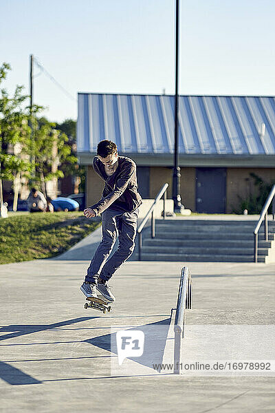 Backside-Flip über Geländer im Skatepark