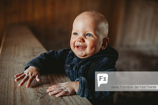 Entzückender kleiner Junge mit blauen Augen  der lächelnd eine Jacke trägt